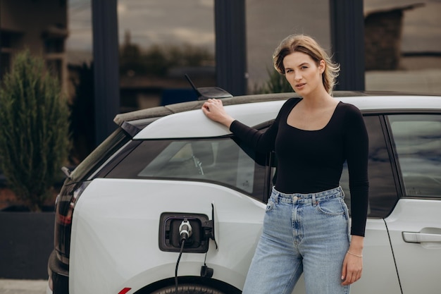 Photo woman charging electro car at the electric gas station