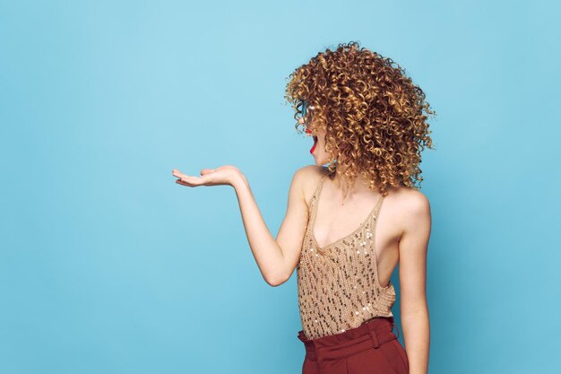 Photo woman charm curly hair emotion side view copy space hand gesture blue isolated background