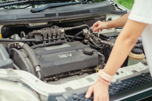 Foto donna che controlla il motore dell'auto prima del viaggio