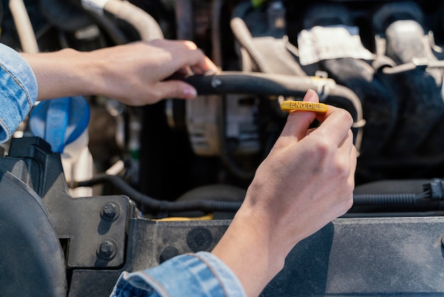 Foto donna che controlla l'olio della sua auto