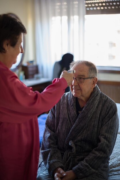 Photo woman checking temperature of patient