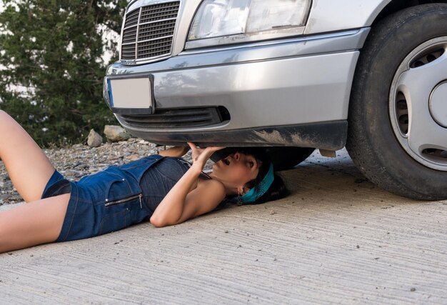 写真 車の問題をチェックしている女性