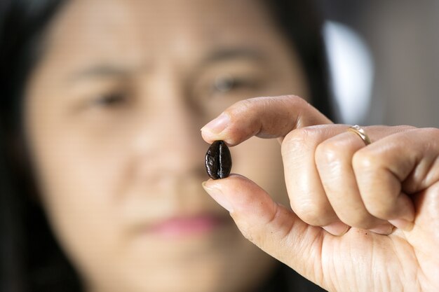 Woman checks a coffee bean roasting for selection high quality