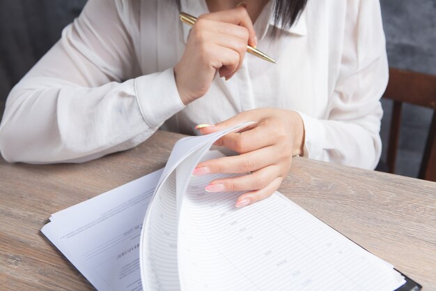 Woman checks papers in front of the table.