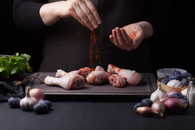 A woman chef prepares a chicken.