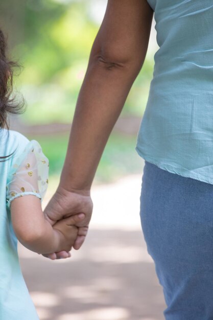 青いシャツを着た女性と子供が手をつないでいる