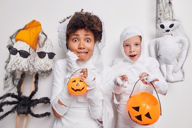  woman and child look with frightened expressions at camera prepare for halloween party hold pumpkins enjoy themed event have happy familiy celebration. Mysterious holiday and decor concept