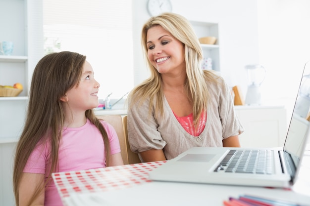 Woman and child smiling at the kitchen 