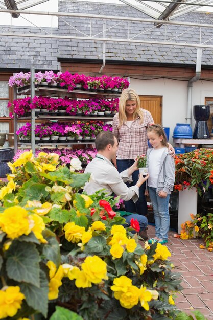 Photo woman and child taking a flower pot from employee