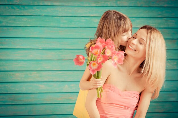 緑の背景に花束の花を持つ女性と子供家族の休日の概念母の日