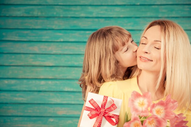 緑の背景に花束の花を持つ女性と子供家族の休日の概念母の日