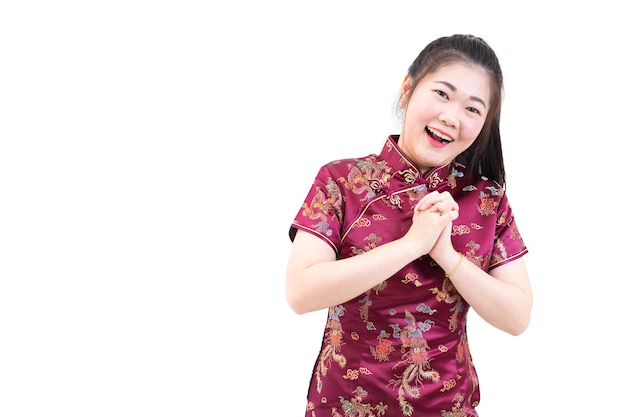 Woman in Chinese long dress, with greeting hands for Chinese New Year 