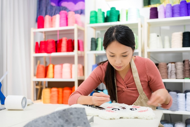 Woman choose the color of thread for making of tufting carpet at studio