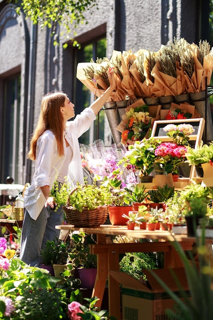 A woman chooses a bouquet of lavender at a flower market outside