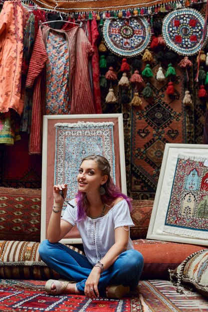 Woman chooses carpet at the market.