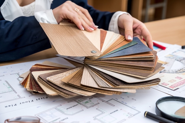 Photo woman chooses designer wood material for modern home