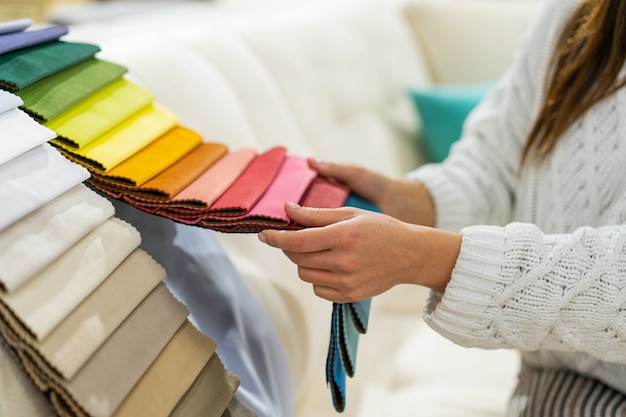 The woman chooses the fabric on the sofa