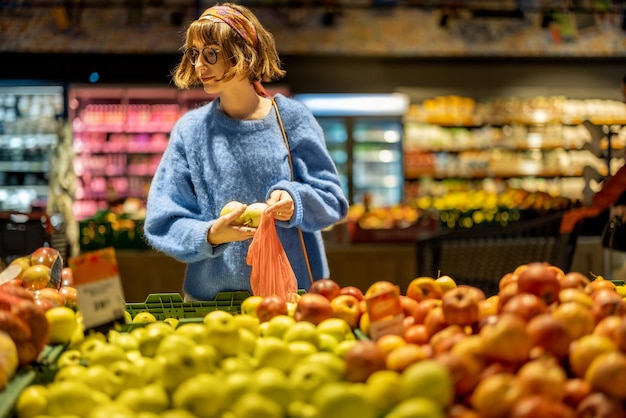 Woman chooses fruits at supermarket