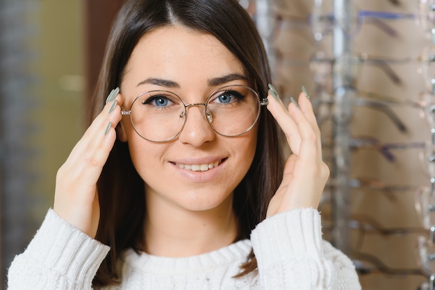 Woman chooses glasses in the store.