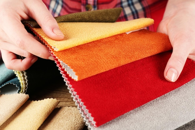 Woman chooses scraps of colored tissue on table close up