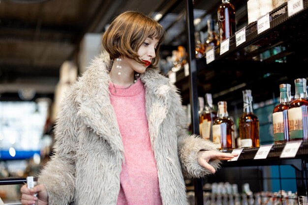 Woman chooses strong alcohol in supermarket