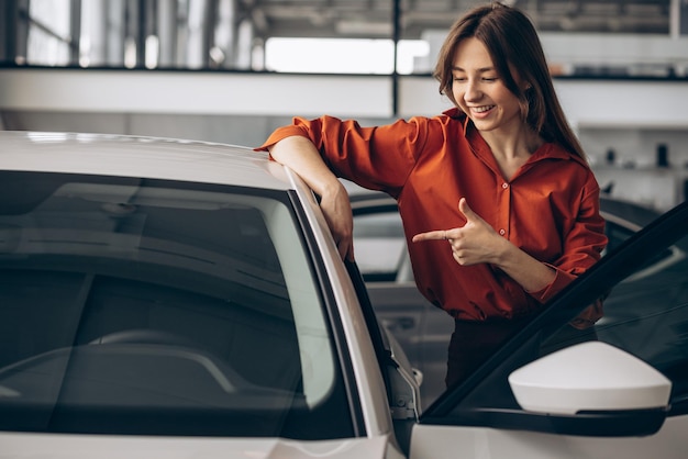 車のショールームで車を選ぶ女性