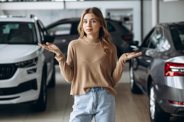 Photo woman choosing a car in car showroom