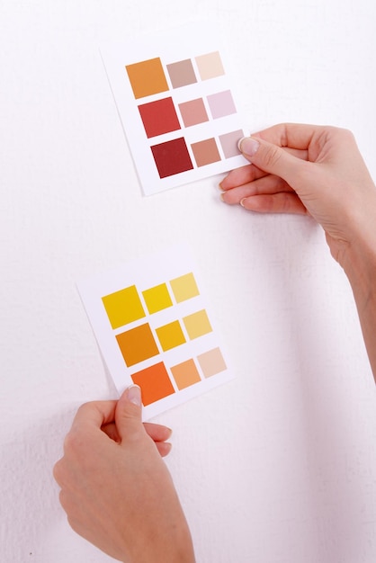 Photo woman choosing color for wall from swatches in room