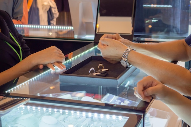 Женщина выбирает кольца с бриллиантами в магазине ювелирных изделий