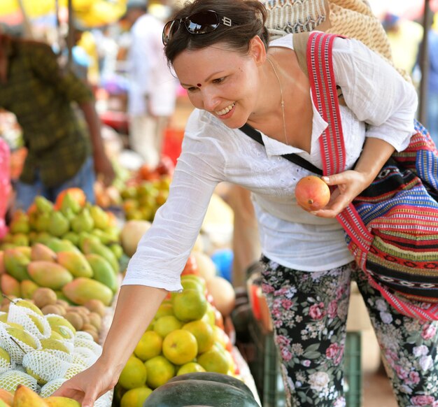 Фото Женщина выбирает свежие фрукты