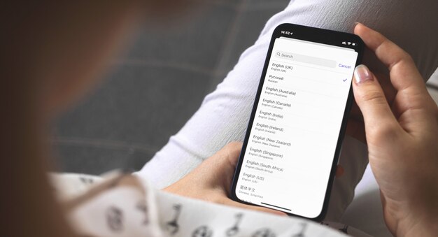 Woman choosing the language on her new mobile phone, language\
settings on the smartphones