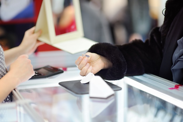 Woman choosing the perfect earrings at a jeweler, close up photo