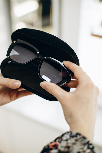 Woman choosing sunglasses at the store