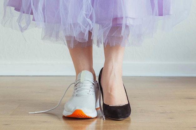 Woman choosing what to wear - sneakers or dress shoes