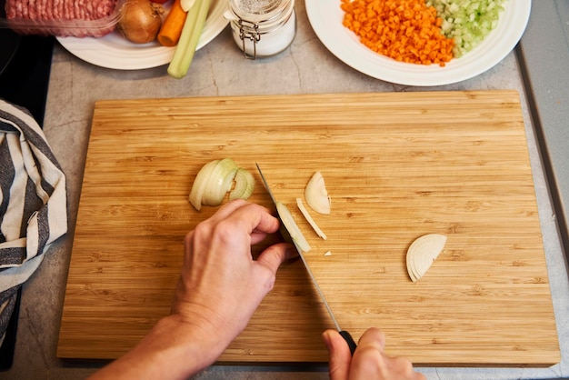 Woman chopping onion in kitchen close up