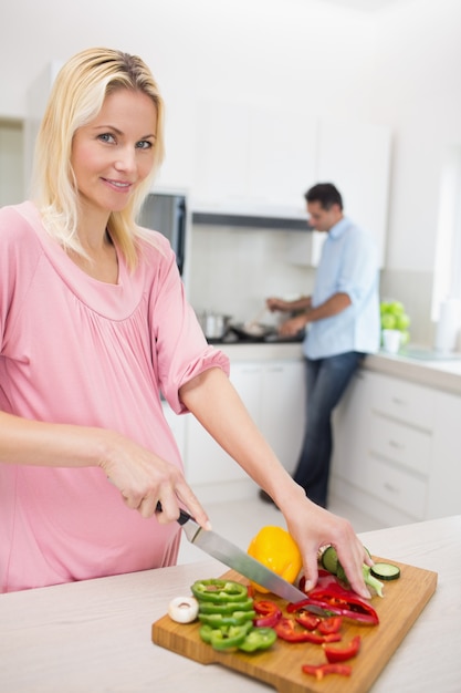 Photo woman chopping vegetables with man doing dishes at kitchen