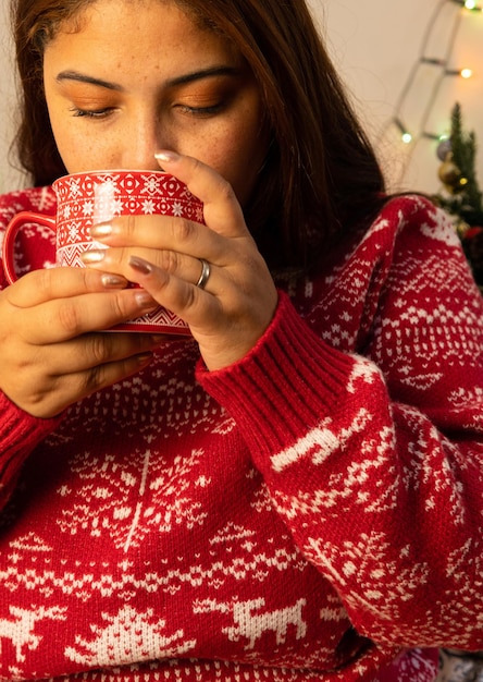 Photo woman at christmas having coffee in christmas cup with christmas sweatshirt