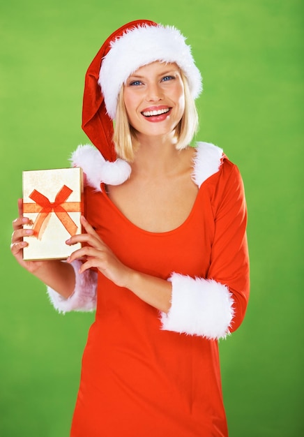 Woman christmas and outfit holiday gift in studio for festive season or smile female person costume and portrait on green background or present box excited celebration winter break or vacation