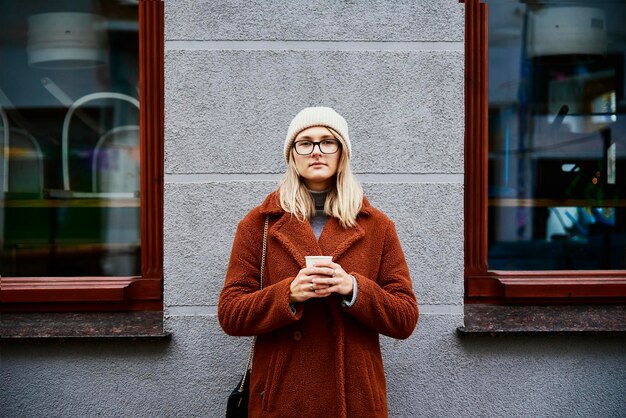 コーヒーカップと街の通りの女性