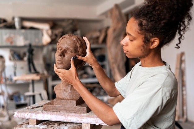 Foto vista laterale della scultura dell'argilla della donna