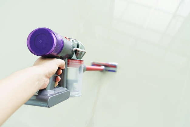 woman clean floor with a vacuum cleaner at home