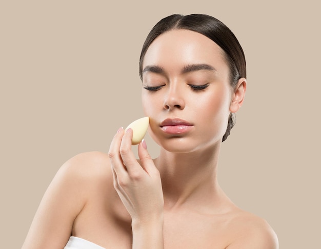 Woman clean skin with sponge beauty healthy skin beauty. Color background. Brown