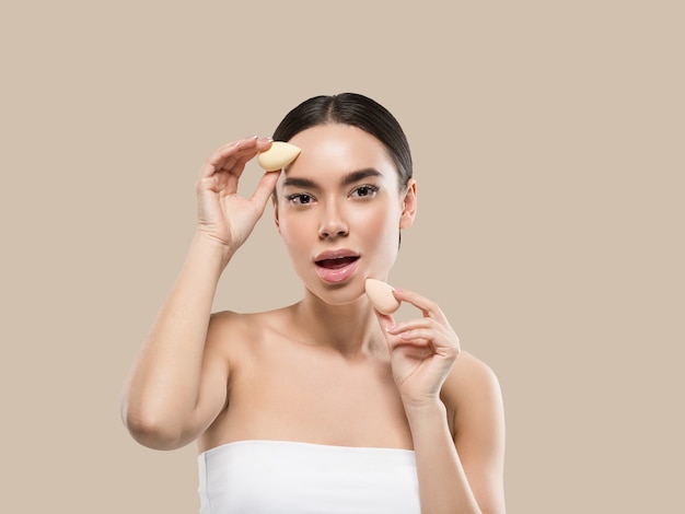 Woman clean skin with sponge beauty healthy skin beauty. color background. brown