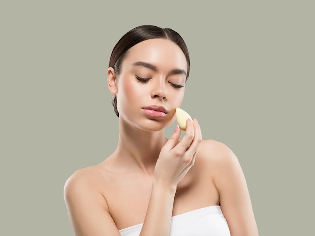 Woman clean skin with sponge beauty healthy skin beauty. Color background. Green