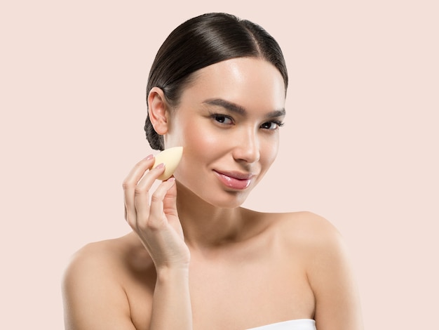 Woman clean skin with sponge beauty healthy skin beauty. Color background. Pink