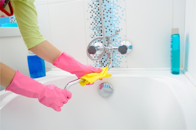 Una donna che pulisce il bagno a casa vasca da bagno e rubinetto di lavaggio femminile