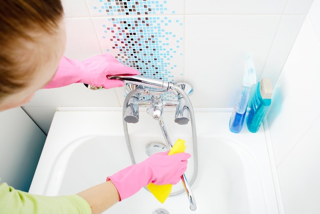 Foto una donna che pulisce il bagno a casa vasca da bagno e rubinetto di lavaggio femminile