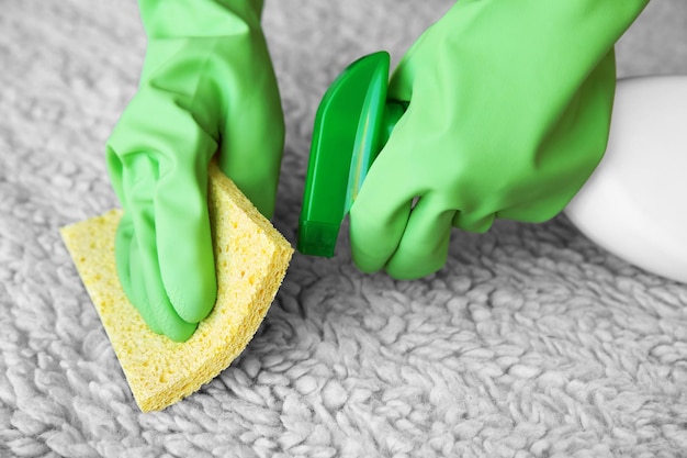 Woman cleaning carpet in room