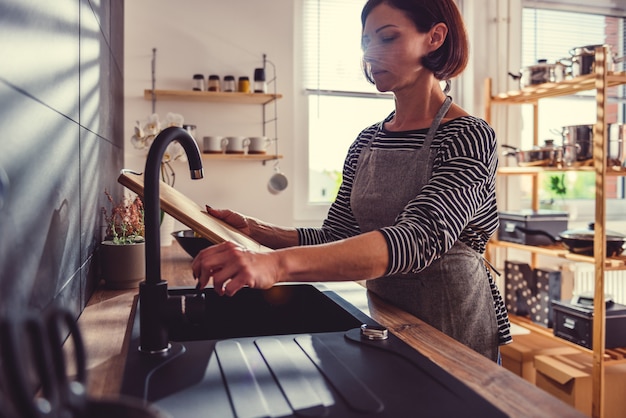 Woman cleaning cutting board