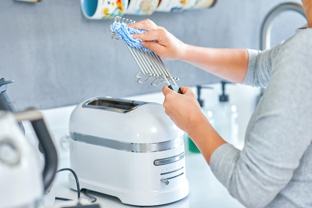 Женщина чистит гриль или тостер на кухне